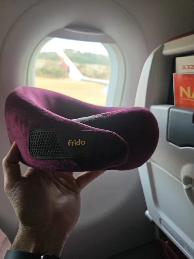 Frido Travel Neck Pillow — neck-support pillow in use on a flight